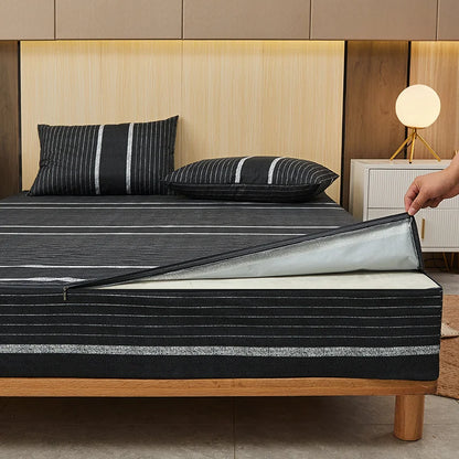 Person unrolling a black striped mattress cover on a bed with wooden headboard.