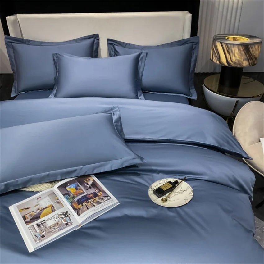 Blue bedding set on a bed with an open magazine and decorative items.