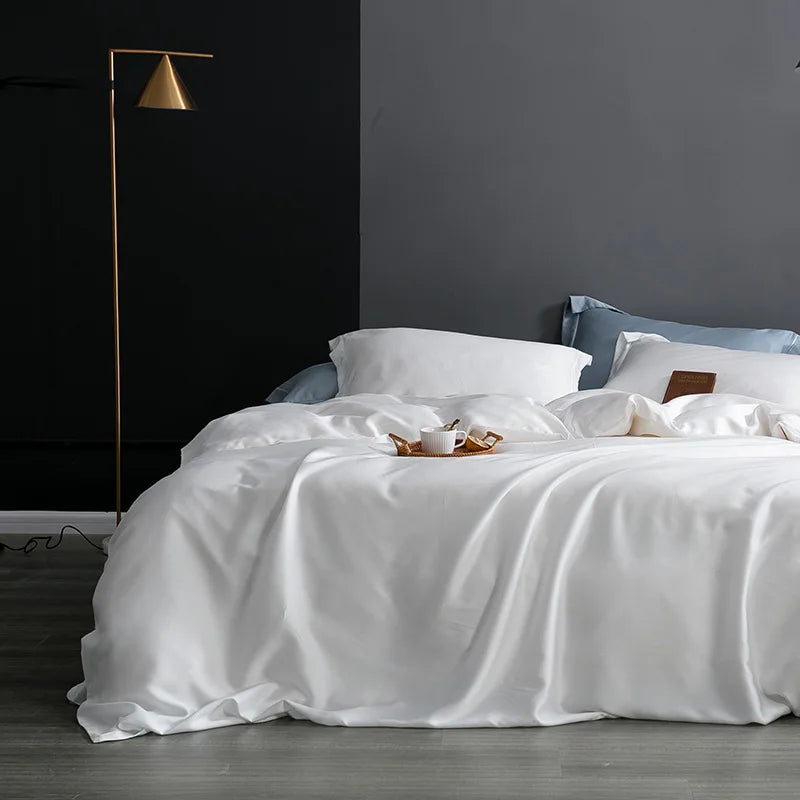 Neatly made bed with white bedding in a bedroom setting.