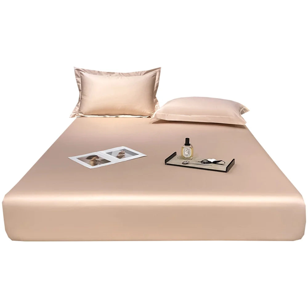 Beige satin sheet set on a bed with pillows and small items.