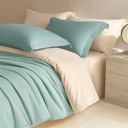 Teal bedding set on a bed with beige pillows and sheets.