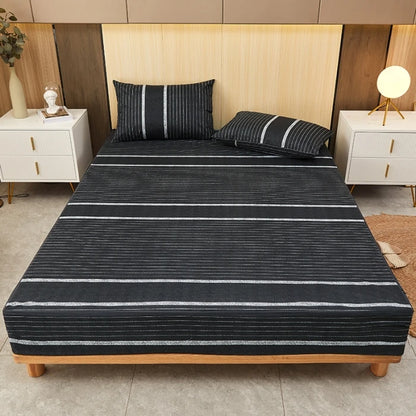 Bed with black and gray striped bedding in a bedroom setting.