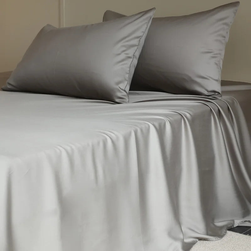 Gray bedding set with two pillows on a bed.