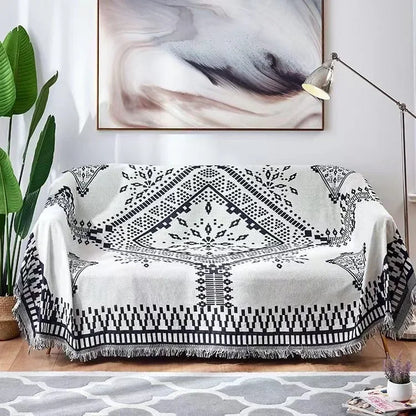 Black and white patterned throw blanket draped over a sofa in a living room.