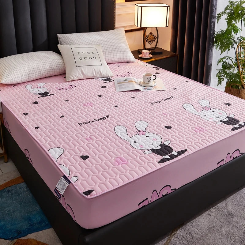 Pink cartoon bedspread on a bed with decorative pillows and a lamp in the background.