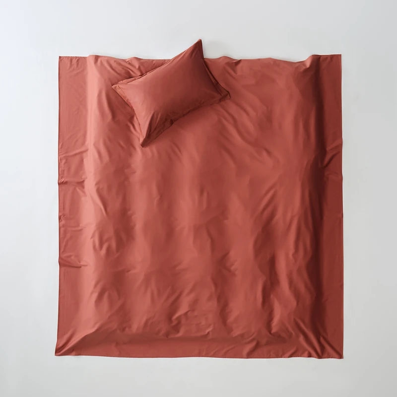 Reddish-brown bedding set with a pillow on a white background