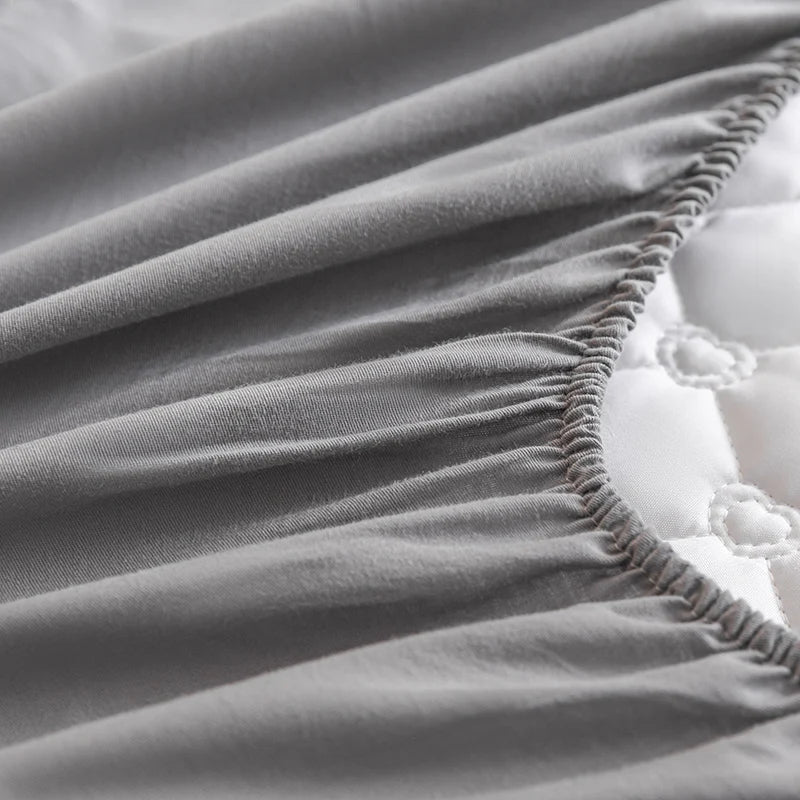 Gray fitted sheet on a bed with white bedding