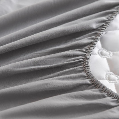 Gray fitted sheet on a bed with white bedding