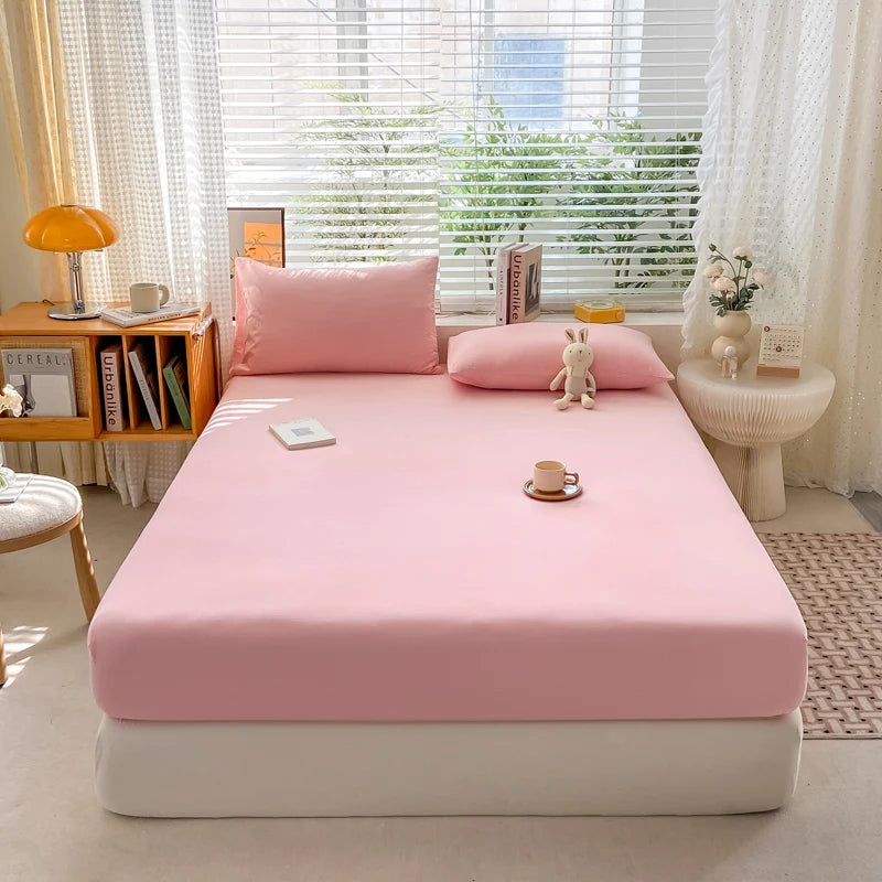 Bed with pink bedding in a bright room with a window and decor items.