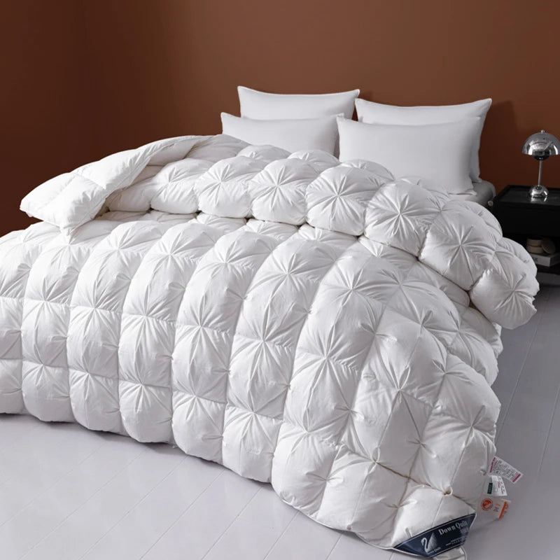 White quilted comforter on a bed with pillows against a brown wall.