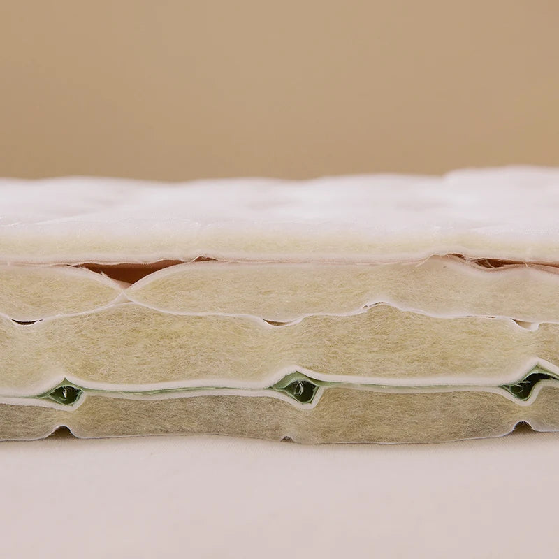 Close-up of a mattress with visible layers on a beige background