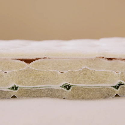 Close-up of a mattress with visible layers on a beige background