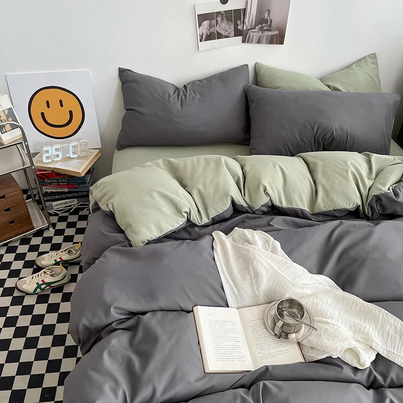 Bedroom with gray and green bedding, books, and a smiley face decor.