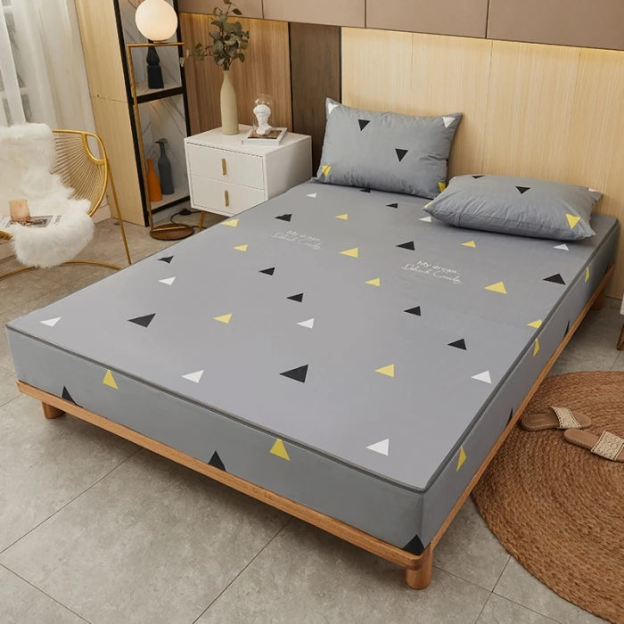 Gray mattress cover with geometric pattern on a bed in a bedroom setting