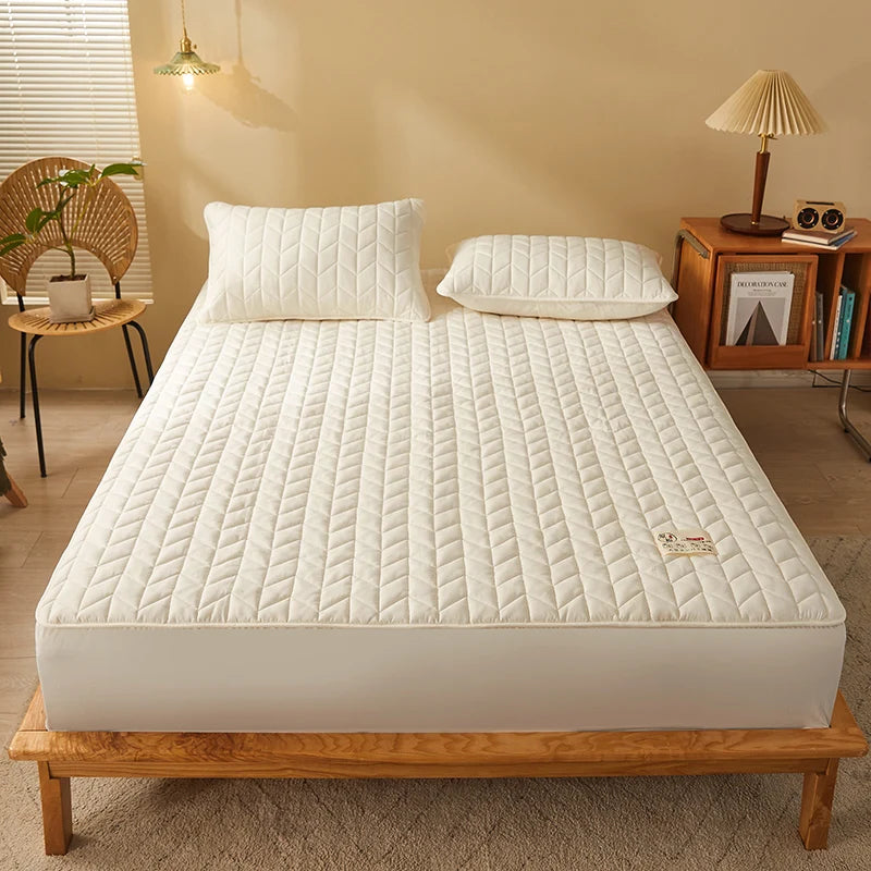 Mattress topper on a bed in a bedroom setting with a lamp and chair.