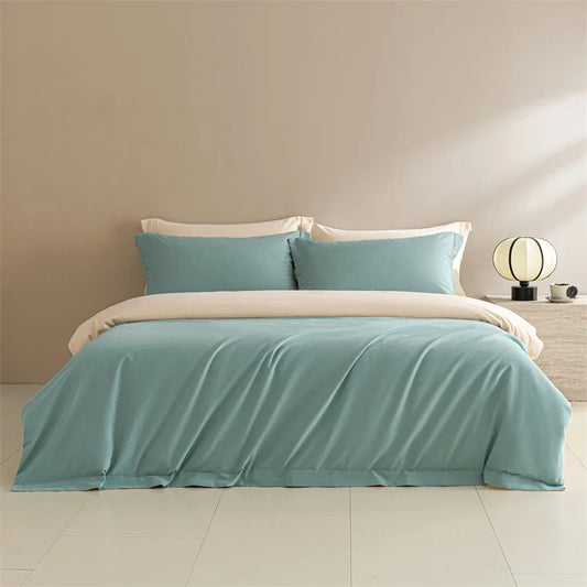 Teal bedspread and pillows on a bed in a minimalistic bedroom setting.