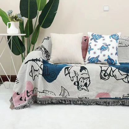 Sofa with cartoon-themed blanket and pillows in a living room setting.