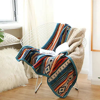 Colorful patterned blanket draped over a chair in a cozy room.
