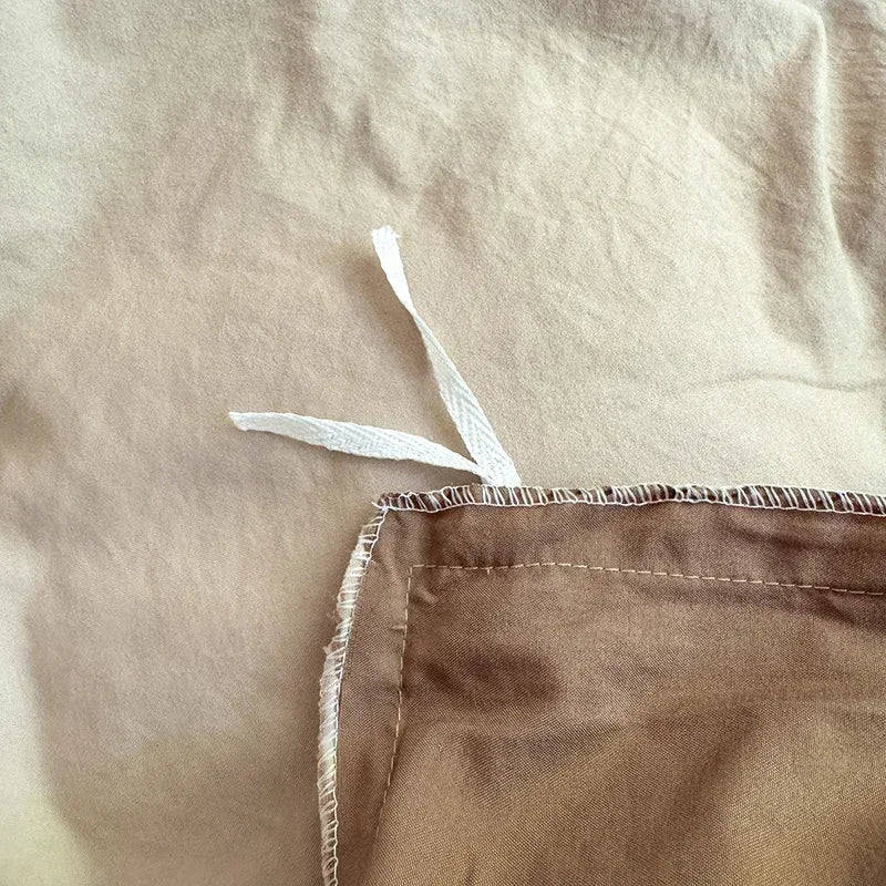 Close-up of beige fabric with a white strip and brown hem