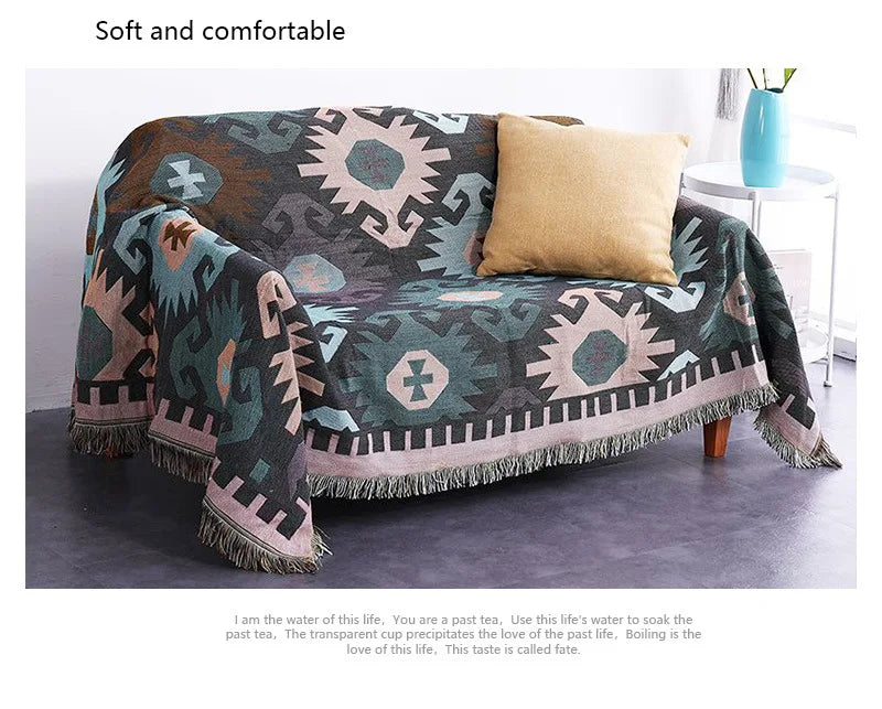Patterned blanket draped over a sofa with a pillow in a room setting.