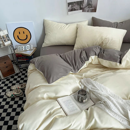 Neatly made bed with gray and white bedding in a room with a checkered floor.