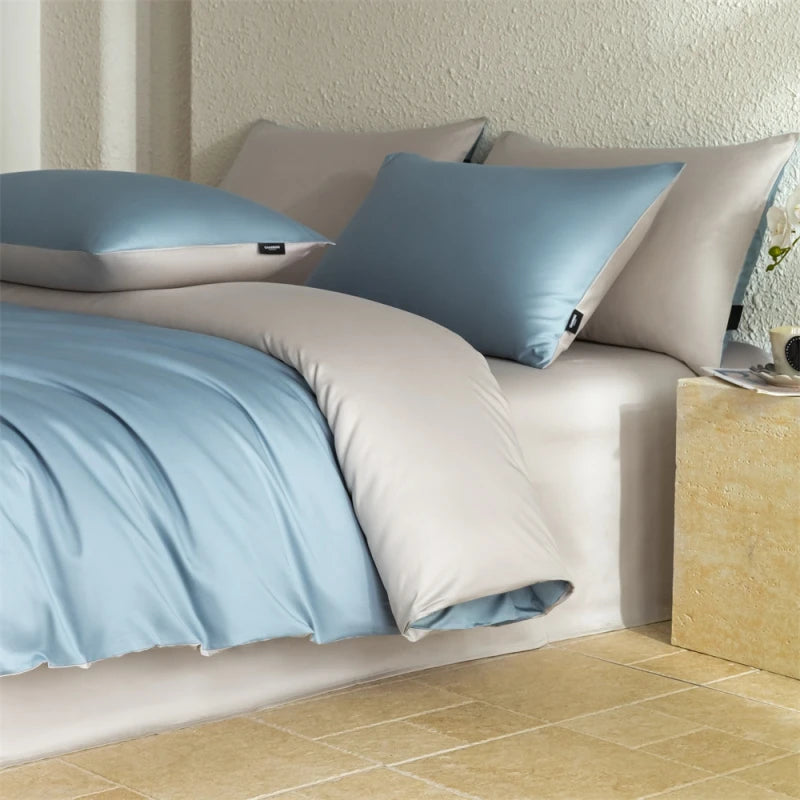 Bed with light blue bedding and pillows in a room with tiled floor.