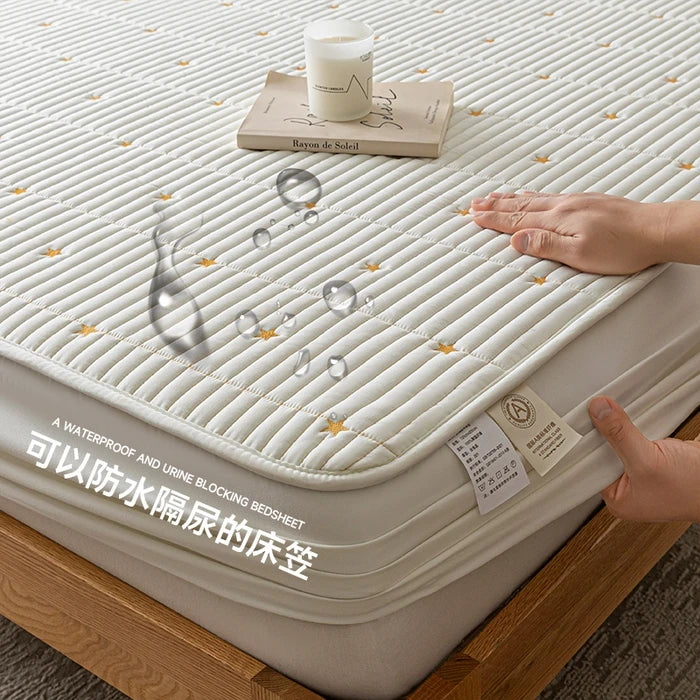 Mattress protector with text on a bed, showing waterproof feature.