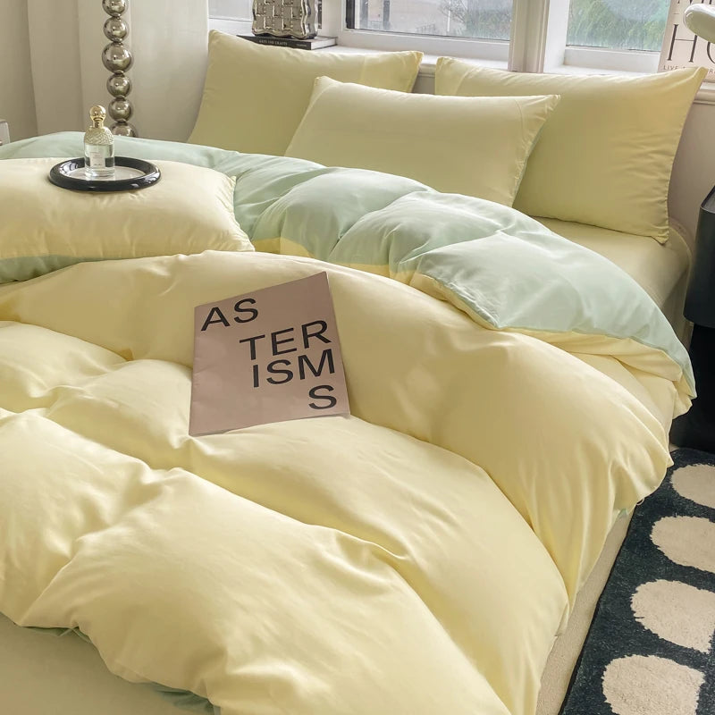 Yellow and green comforter on a bed with a pillow labeled 'AS TERISMS'.