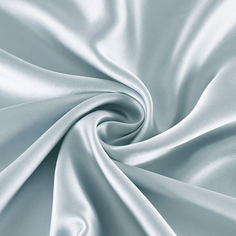 Close-up of light blue satin fabric with folds