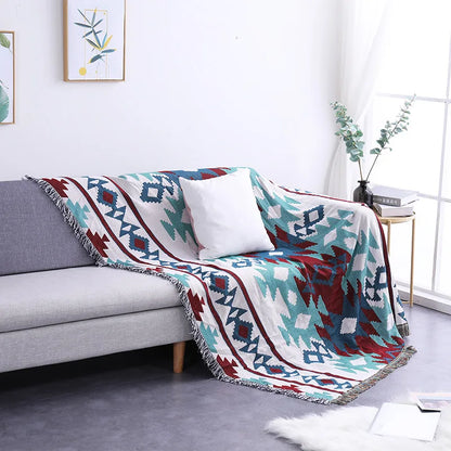 Colorful patterned blanket draped over a gray sofa in a living room.