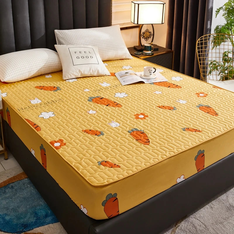 Yellow mattress cover with carrot pattern on a bed in a bedroom setting.