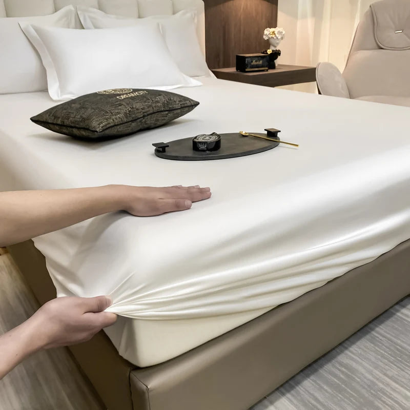Person adjusting a fitted sheet on a bed in a bedroom setting.
