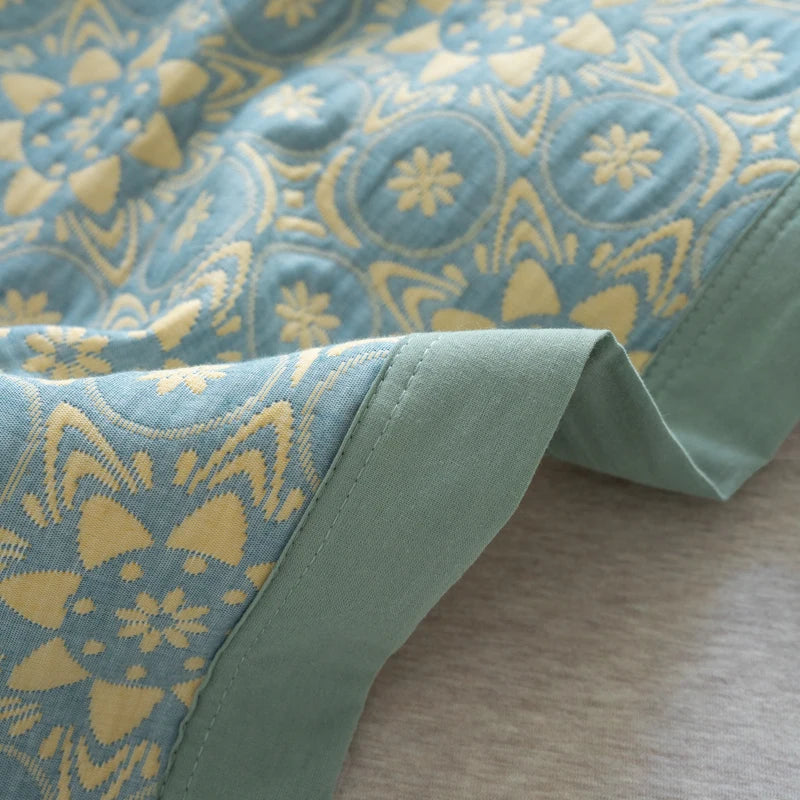Close-up of a blue and yellow patterned fabric with a green border.
