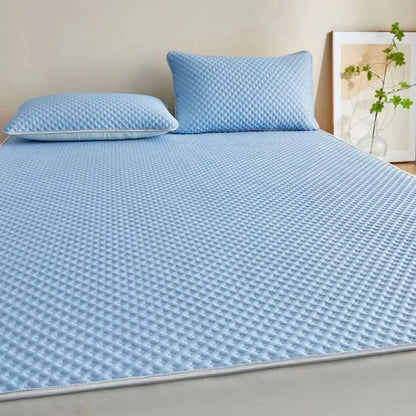 Blue checkered bedspread on a bed with matching pillows, in a room setting.