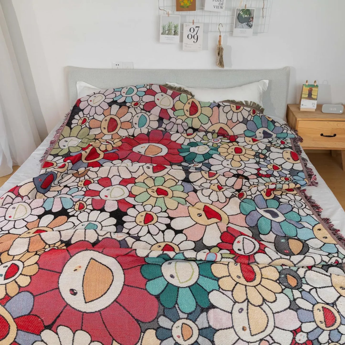 Colorful floral-patterned blanket on a bed in a bedroom setting.