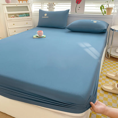 Blue bedsheet set on a bed with pillows and a cup in a bedroom setting.