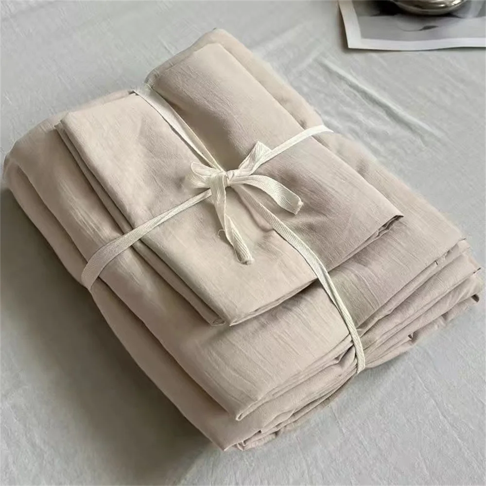 Folded beige fabric with a ribbon on a light gray surface