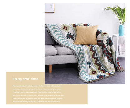 Decorative blanket with geometric pattern draped over a sofa in a living room setting.