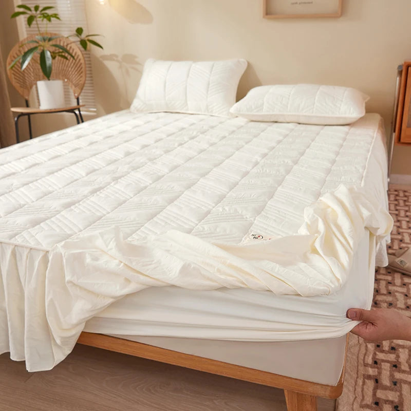 Mattress pad being fitted onto a bed in a bedroom setting