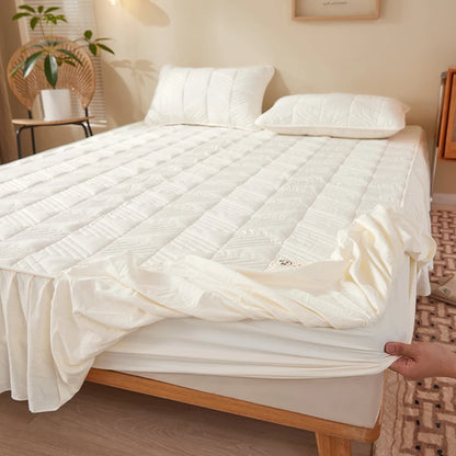 Mattress pad being fitted onto a bed in a bedroom setting