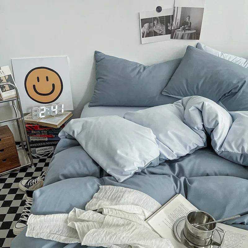 Blue bedding set on a bed with a checkered floor and books in the background