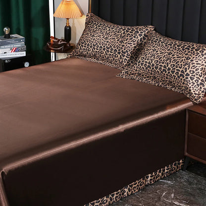 Bed with brown satin sheets and leopard print pillowcases in a bedroom setting.
