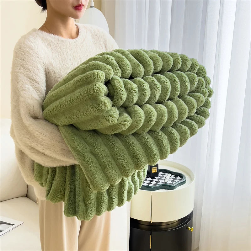 Person holding a large green knitted blanket in a room with white curtains.