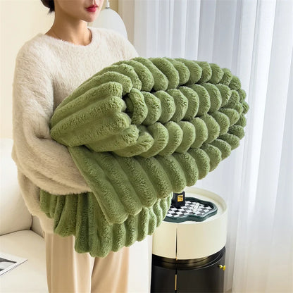 Person holding a large green knitted blanket in a room with white curtains.