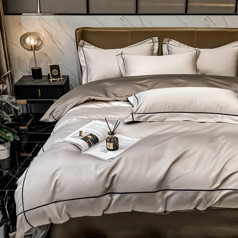 Neatly made bed with beige and white bedding in a modern bedroom setting.