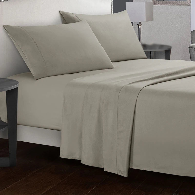 Beige bed sheets and pillows on a neatly made bed in a bedroom setting.