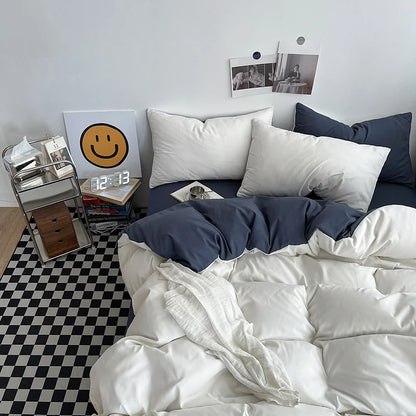 Bedroom with white bedding, blue blanket, and a smiley face poster on the wall.