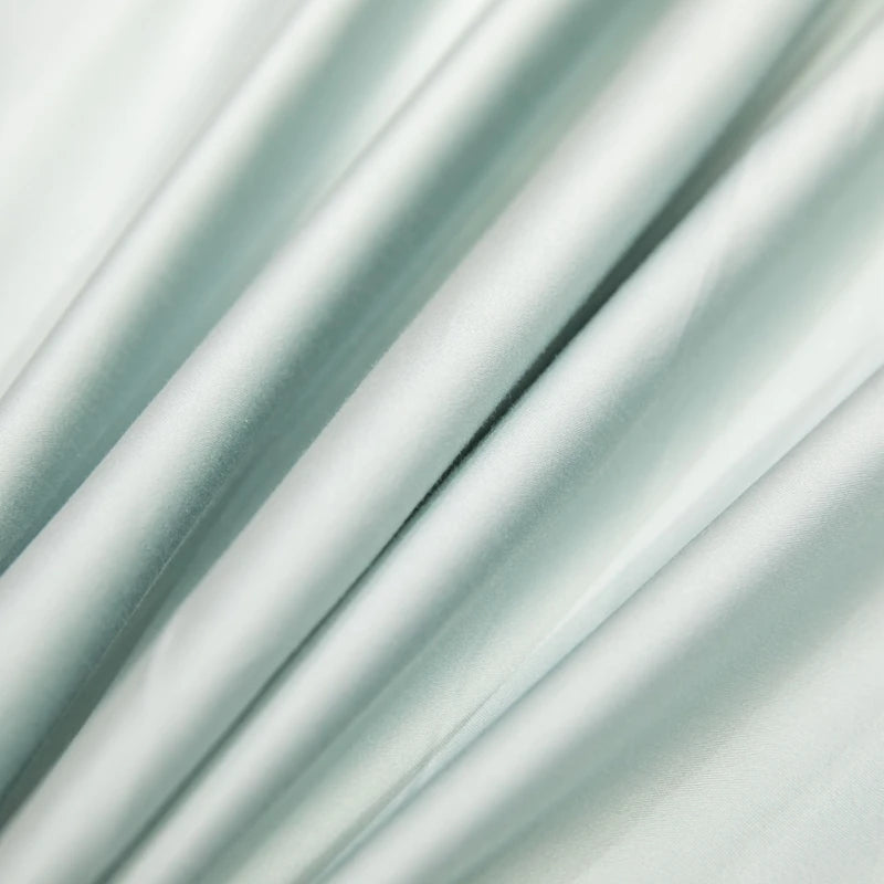 Close-up of light green satin fabric with folds