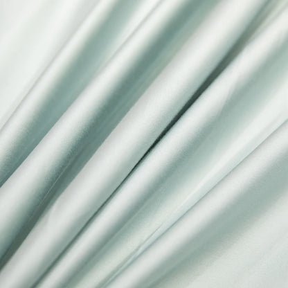 Close-up of light green satin fabric with folds