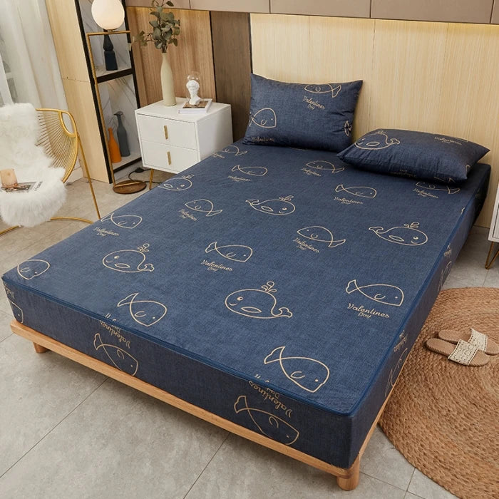 Blue mattress cover with whale pattern on a bed in a bedroom setting.
